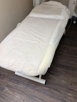 a bed with a white sheet on it in a room