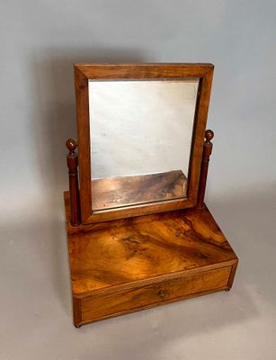 a small mirror sitting on top of a wooden stand