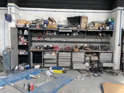un établi dans un garage, sur lequel sont posés de nombreux outils