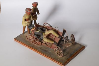 figurine of a man with a horse drawn carriage and a man on a horse drawn carriage