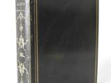 an old black book with gold trim and a black cover
