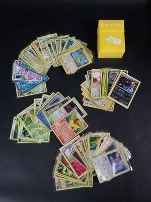 a lot of pokemon cards and a yellow box on the table
