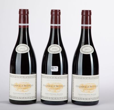 three bottles of red wine sitting next to each other on a table