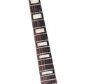 an electric guitar with a black body sitting on a white surface