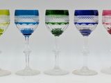 several different colored wine glasses are lined up in a row