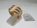 une image d'une bague en or sur une surface blanche avec une étiquette de prix