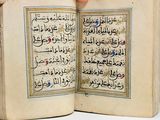 someone is holding a book open with arabic writing on it