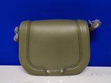 un petit sac à main vert posé sur un comptoir blanc