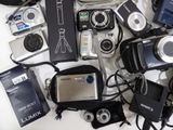 many different types of digital cameras and accessories on the table