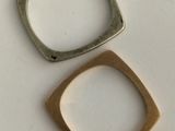 two pieces of silver and gold on a white surface