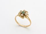 a close up of a gold ring with a green stone