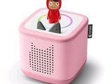 une petite enceinte rose sur laquelle est posé un chat