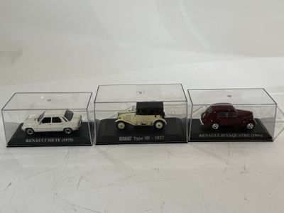 trois modèles réduits de voitures différents sont exposés dans une vitrine posée sur une surface blanche