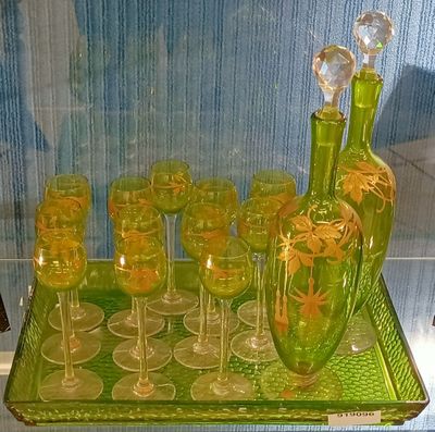a green glass tray with wine glasses and a bottle on it