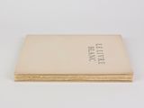 an open book sitting on top of a table next to a white wall