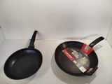 two frying pans sitting on a counter top