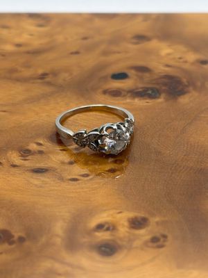 une photo d'une bague en diamant posée sur une table en bois