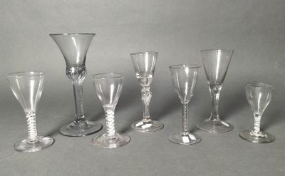 several empty wine glasses are lined up on a gray surface