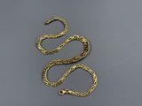 a gold plated chain with a clasp on a gray surface