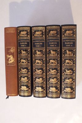 trois livres sont alignés les uns à côté des autres sur une étagère