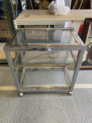 une table en verre surmontée d'un piètement en métal