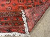 a red area rug on the floor next to a brown area rug