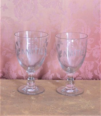 deux verres à vin posés sur une table, avec un fond de papier peint en arrière-plan