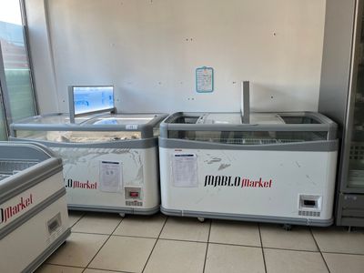 Plusieurs machines à glaces sont alignées dans un magasin