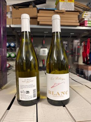 deux bouteilles de vin posées sur une table l'une à côté de l'autre