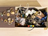 a box filled with assorted jewelry on a wooden table