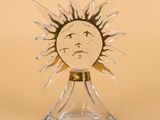 an image of a glass sculpture of a sun with a face