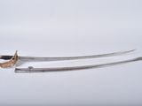 pair of two swords on a white surface with a white background
