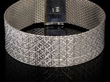 gros plan d'un bracelet en argent sur une surface noire