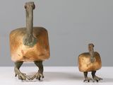 two bronze birds that are standing next to each other