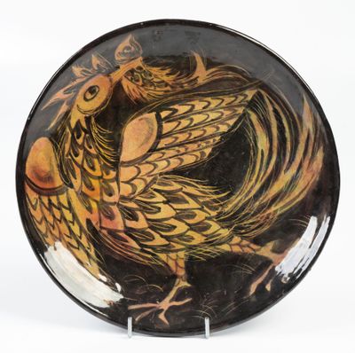une assiette noire et jaune sur laquelle est peint un oiseau
