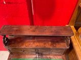a small wooden chest with a green mat on the floor