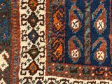 a close up of a blue and orange rug with a bird on it