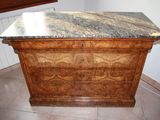 a marble top dresser in the corner of a room