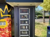 un distributeur automatique de pizzas sur lequel est posée une couronne