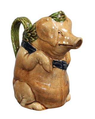 un petit cochon en céramique avec un nœud papillon autour du cou