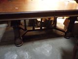 une grande table en bois qui se trouve au milieu d'une pièce