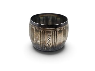 une tasse en argent posée sur une surface blanche