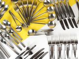 de nombreuses cuillères et fourchettes disposées sur une table