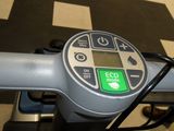 a green button on the handlebar of a bicycle