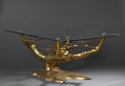une table en verre sur laquelle trône un sapin doré