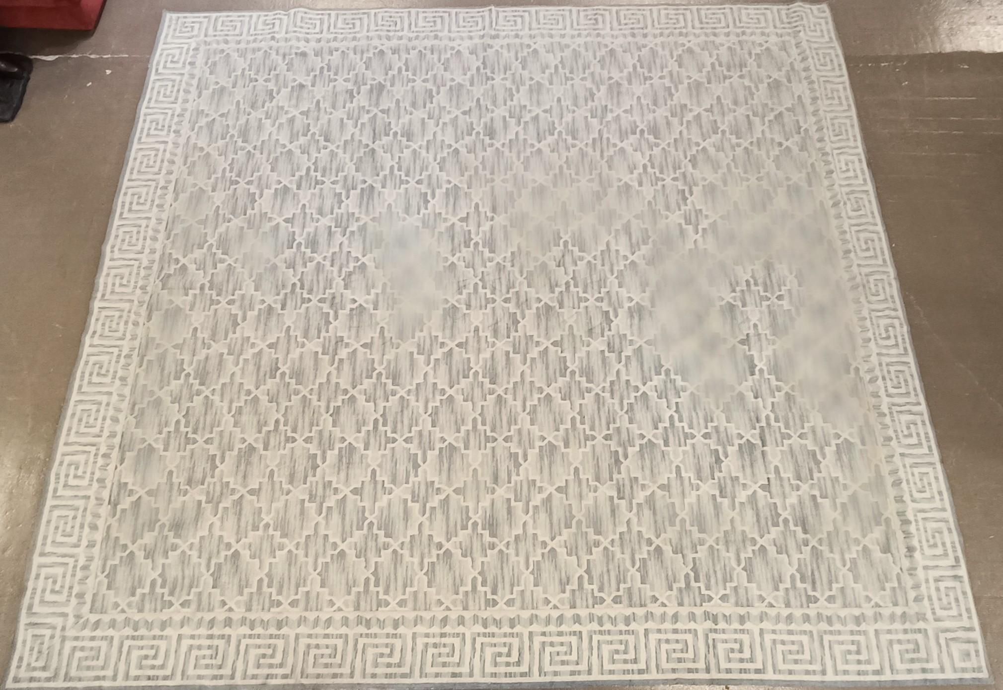Grand tapis rectangulaire à décor géométrique de méandres grecques et polylobes blanc et bleu clair. Travail contempo...