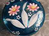 a blue plate with pink flowers painted on it