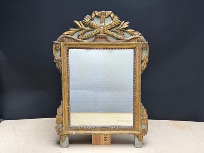 un miroir ancien avec un cadre doré et un socle en bois