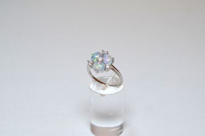an image of a ring with a white oplite in it on a clear glass stand