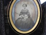 a picture of a woman in a black dress sitting in a chair